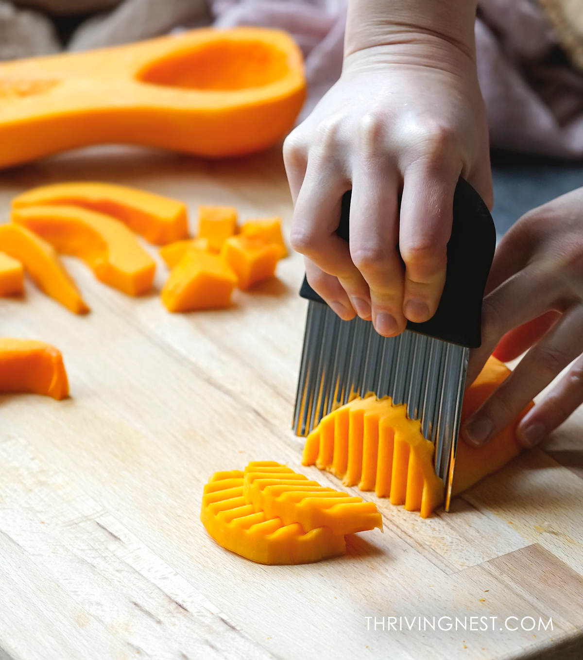 Cutting butternut squash for baby led weaning with a crinkle cut knife.