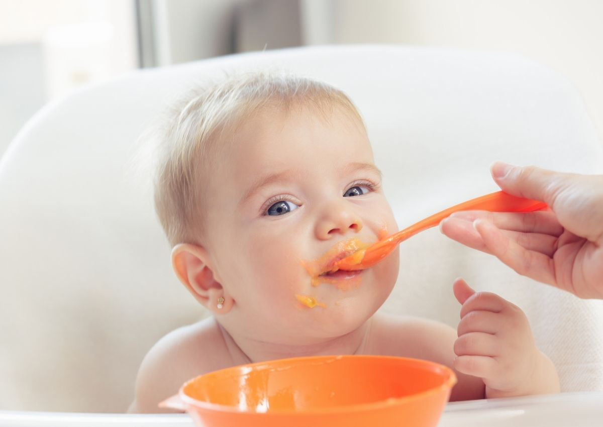 Baby eating carrot puree.