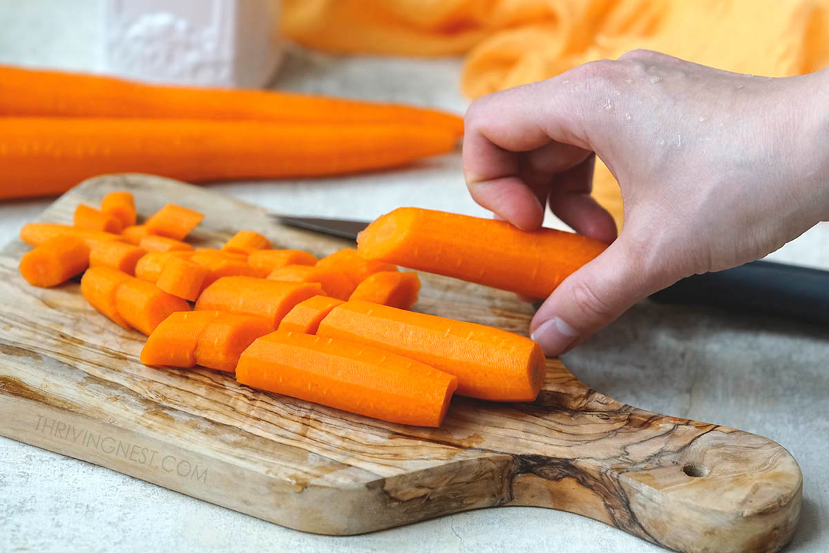 Chopping peeled carrots for soup.