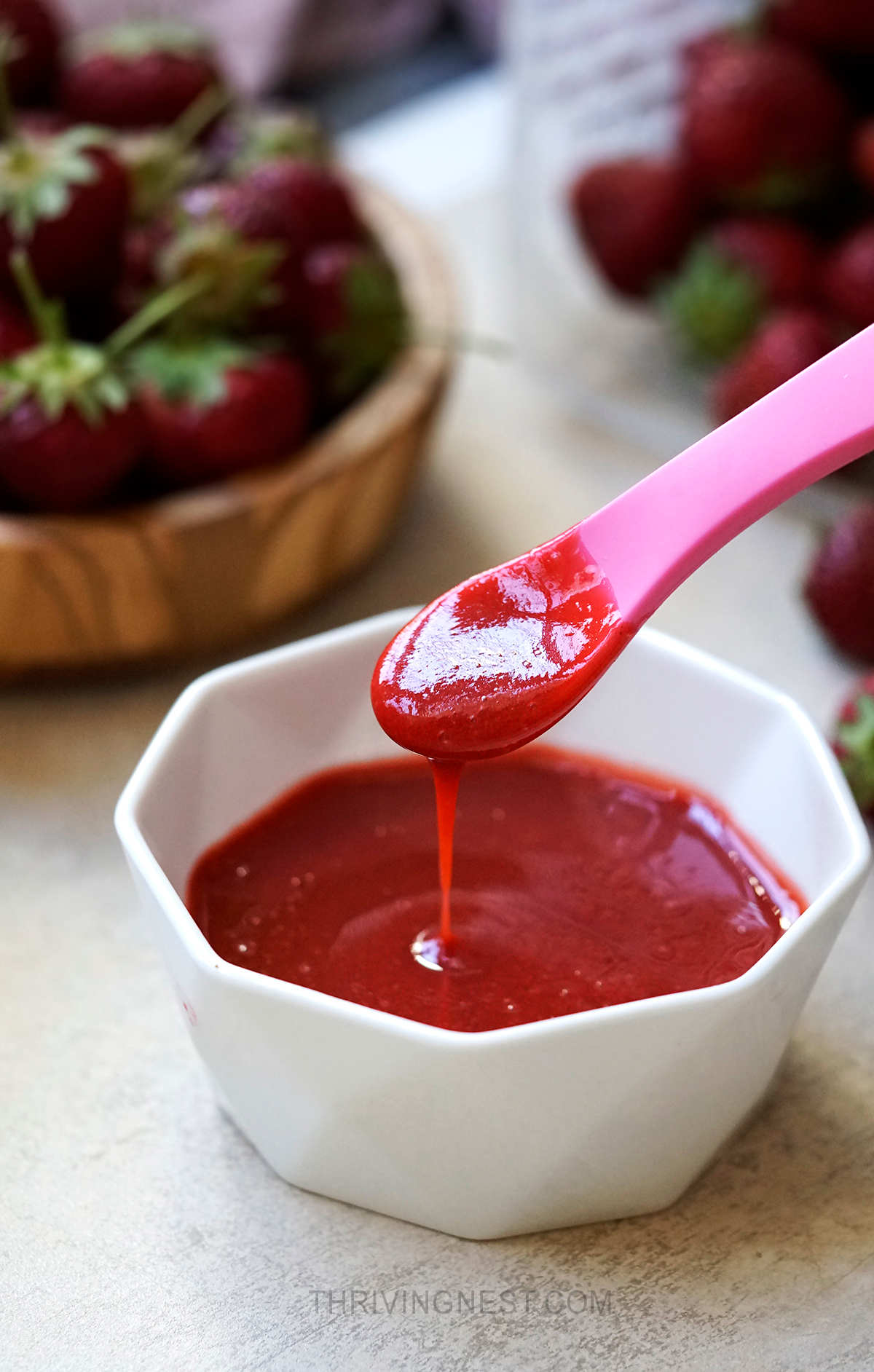 Strawberry puree for baby in a small bowl.