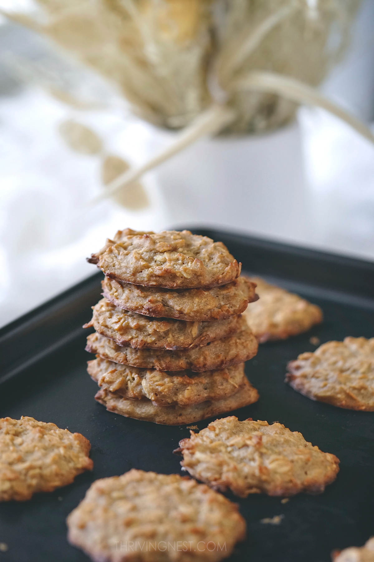Stacked oatmeal cookies on a baking sheet.
