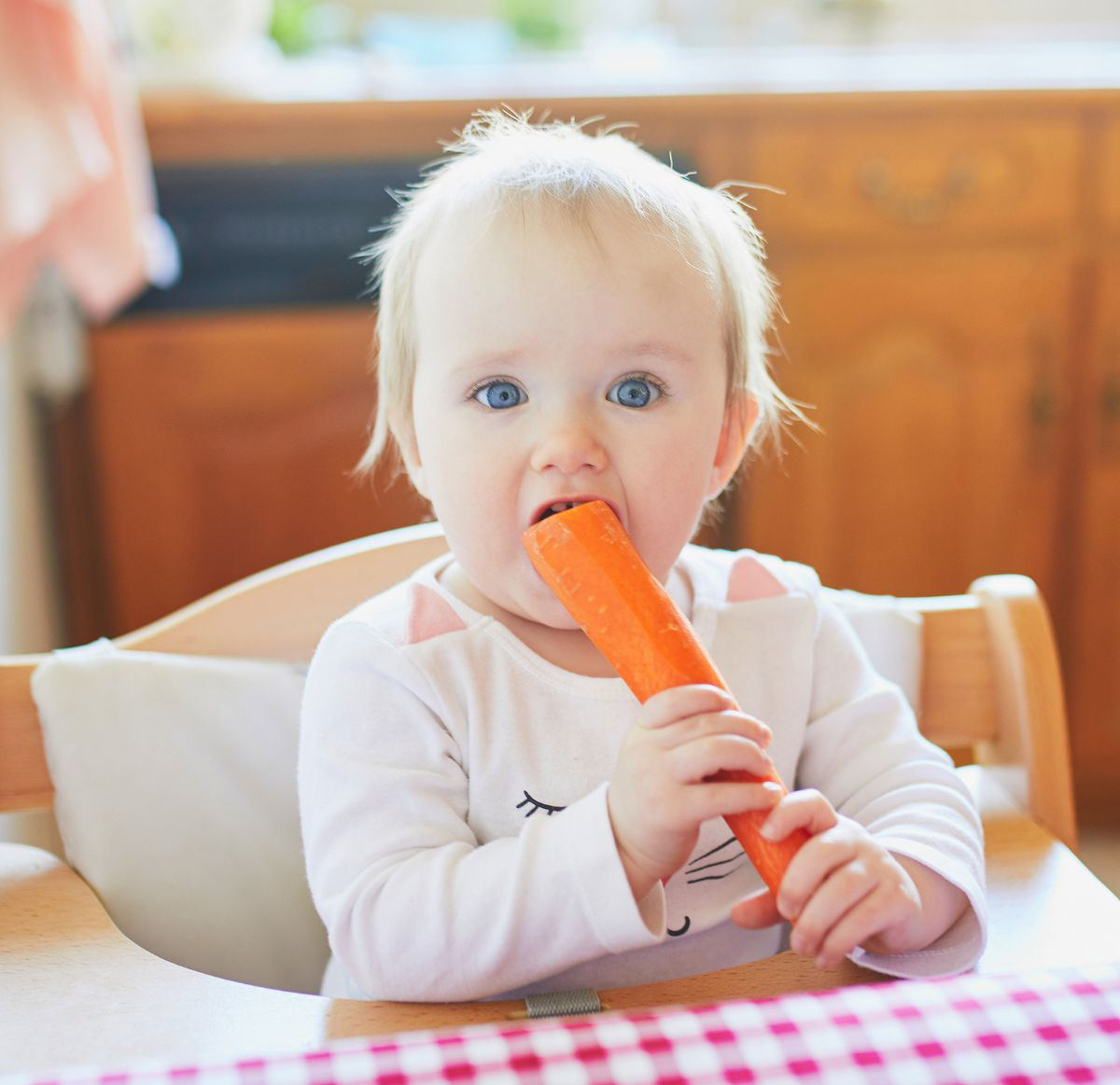 baby eating whole raw carrot
