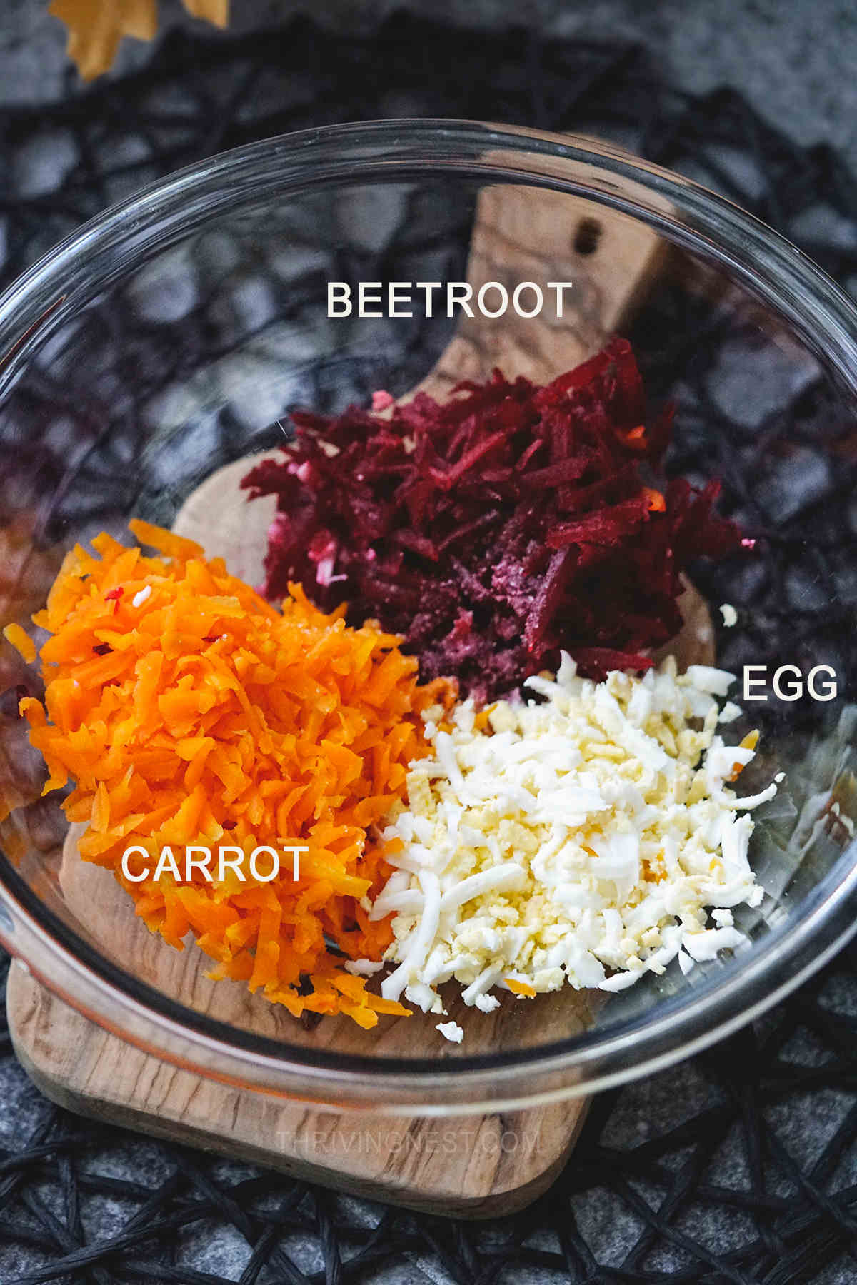 Ingredients for this salad grated and placed in a bowl: carrot, beet and egg.