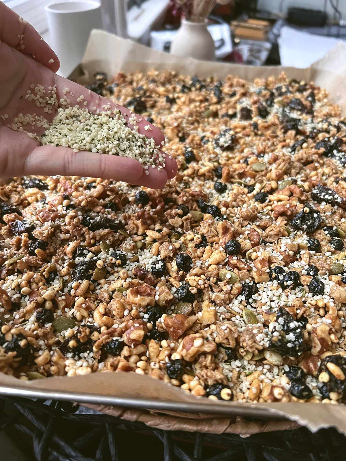 Adding hemp seeds to the baked granola.