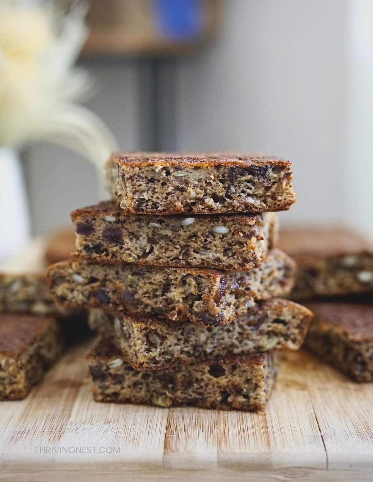 Banana sheet pan pancakes cut into soft, moist squares and stacked showing inside texture.